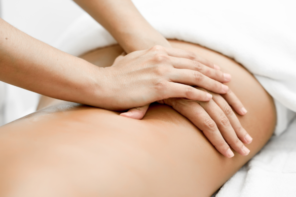 Young woman receiving a back massage in a spa center. Young woman receiving a back massage in a spa center. Female patient is receiving treatment by professional therapist.